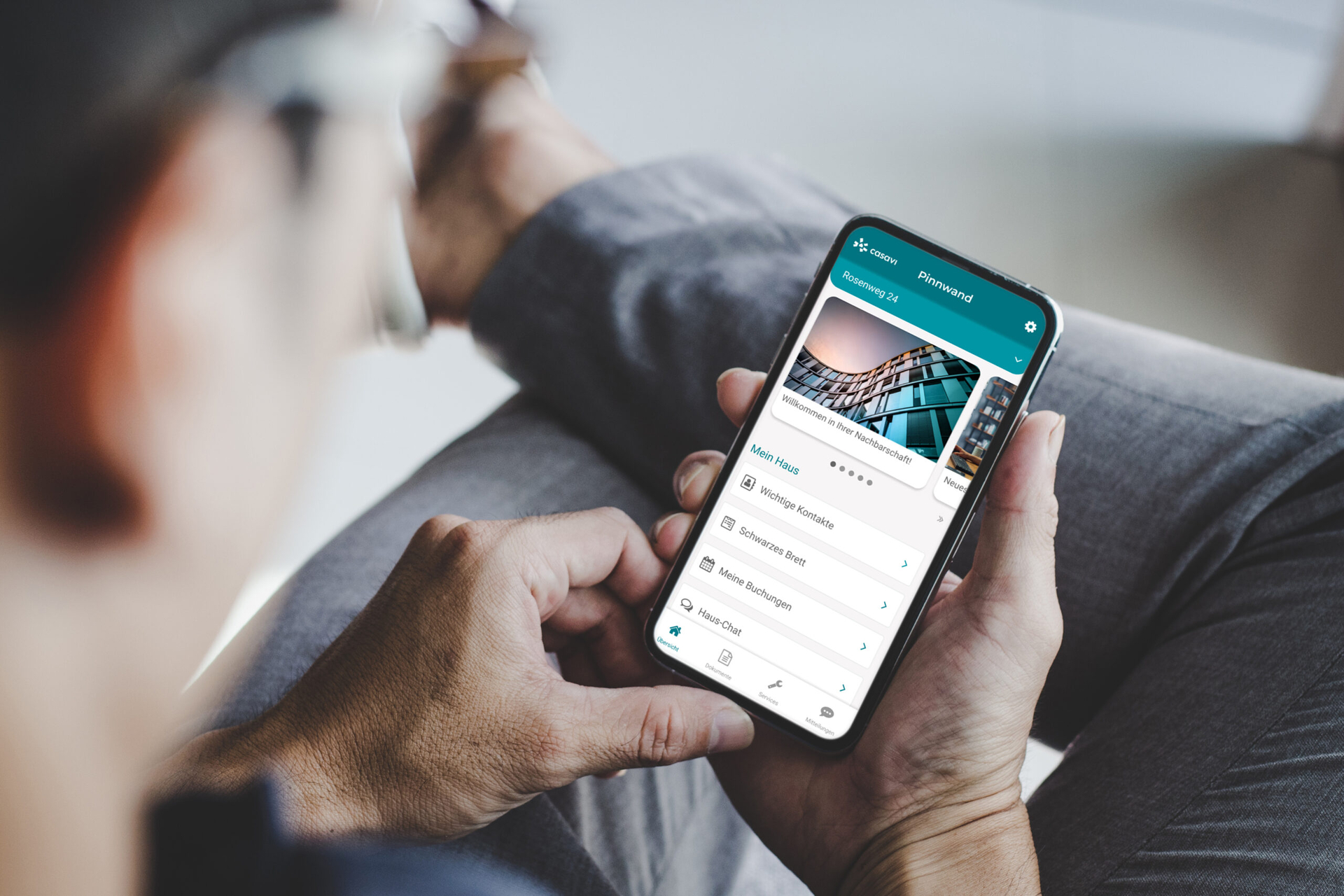 Ein Mann schaut auf sein Mobiltelefon auf dem die Service-App geöffnet ist.