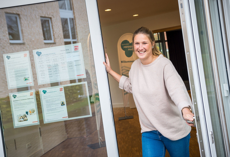 Quartiersmanagerin Vivien Behrens Die Quartiersmanagerin Vivien Behrens öffnet freundlich lächelnd die Tür des Quartiershauses Middenmang.