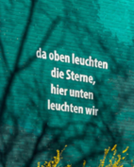 Detail aus dem "Laternenumzug": Spruch aus dem Kinderlied. Da oben leuchten die Sterne, hier unten leuchten wir.